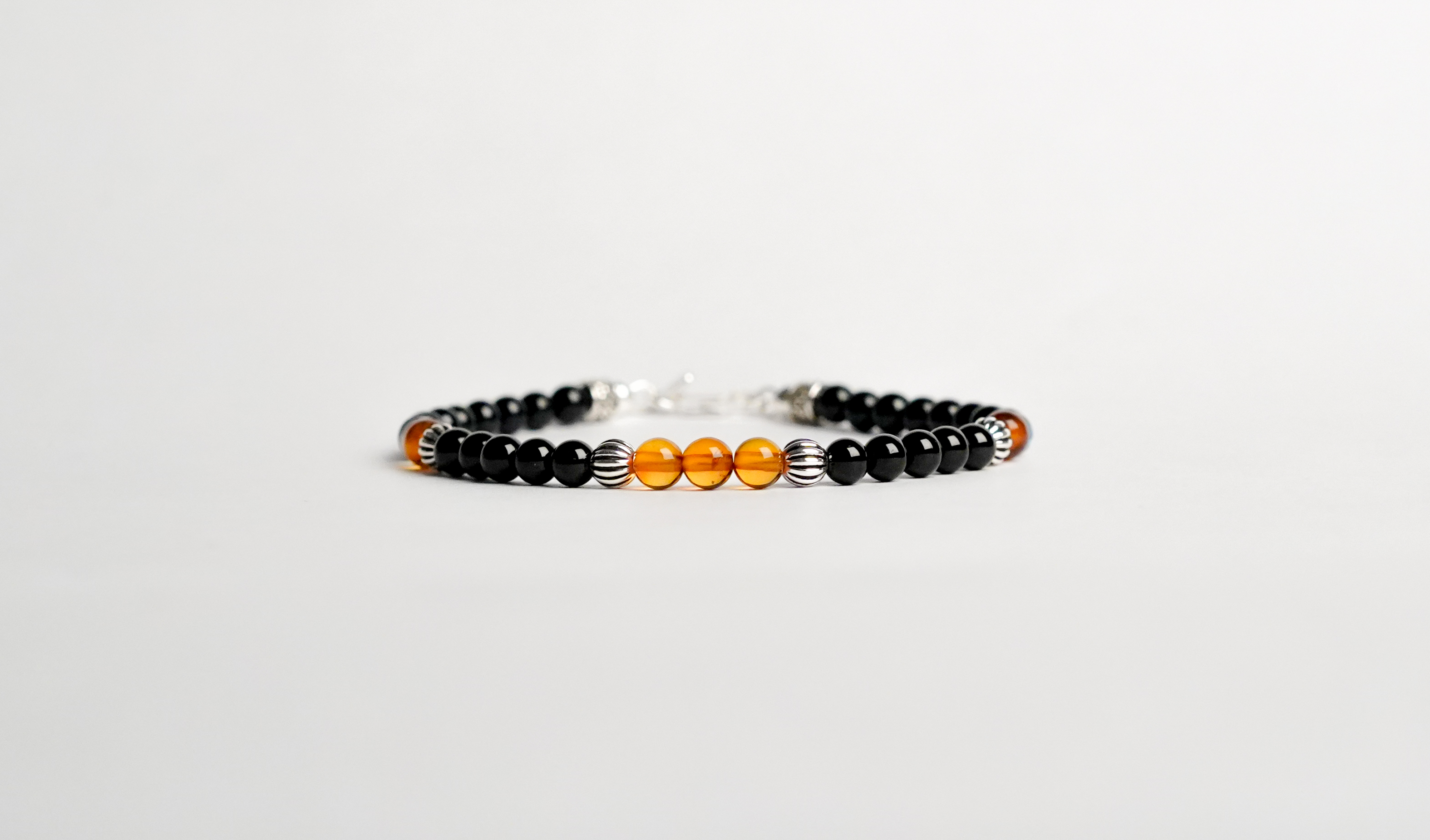 Il bracciale è realizzato con perle di Tormalina nera, Labradorite e Ambra baltica.