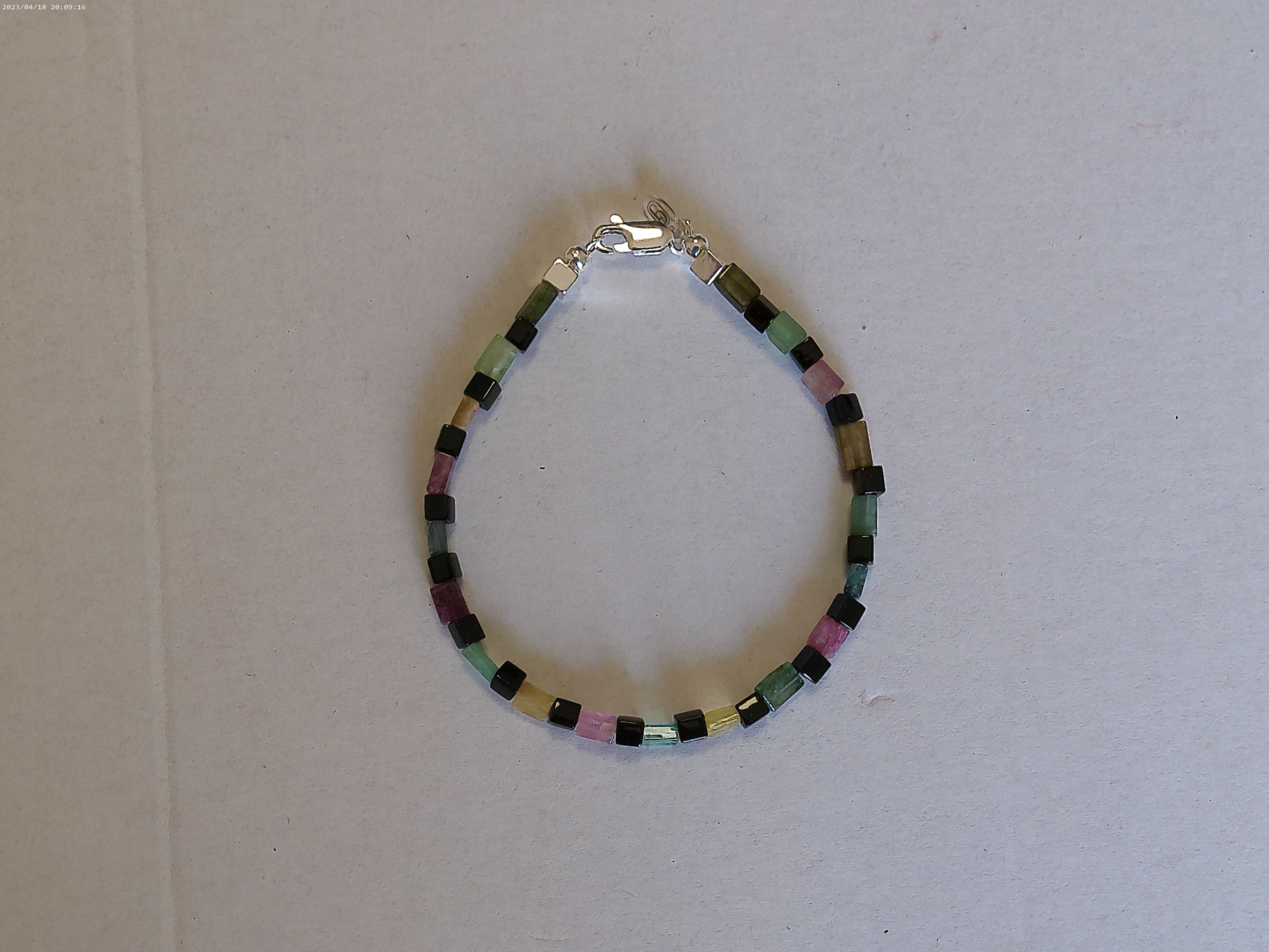 Il bracciale è realizzato con gemme di Tormalina multicolore a forma di parallelepipedo rettangolo e dadini di vetro Miyuki nero.