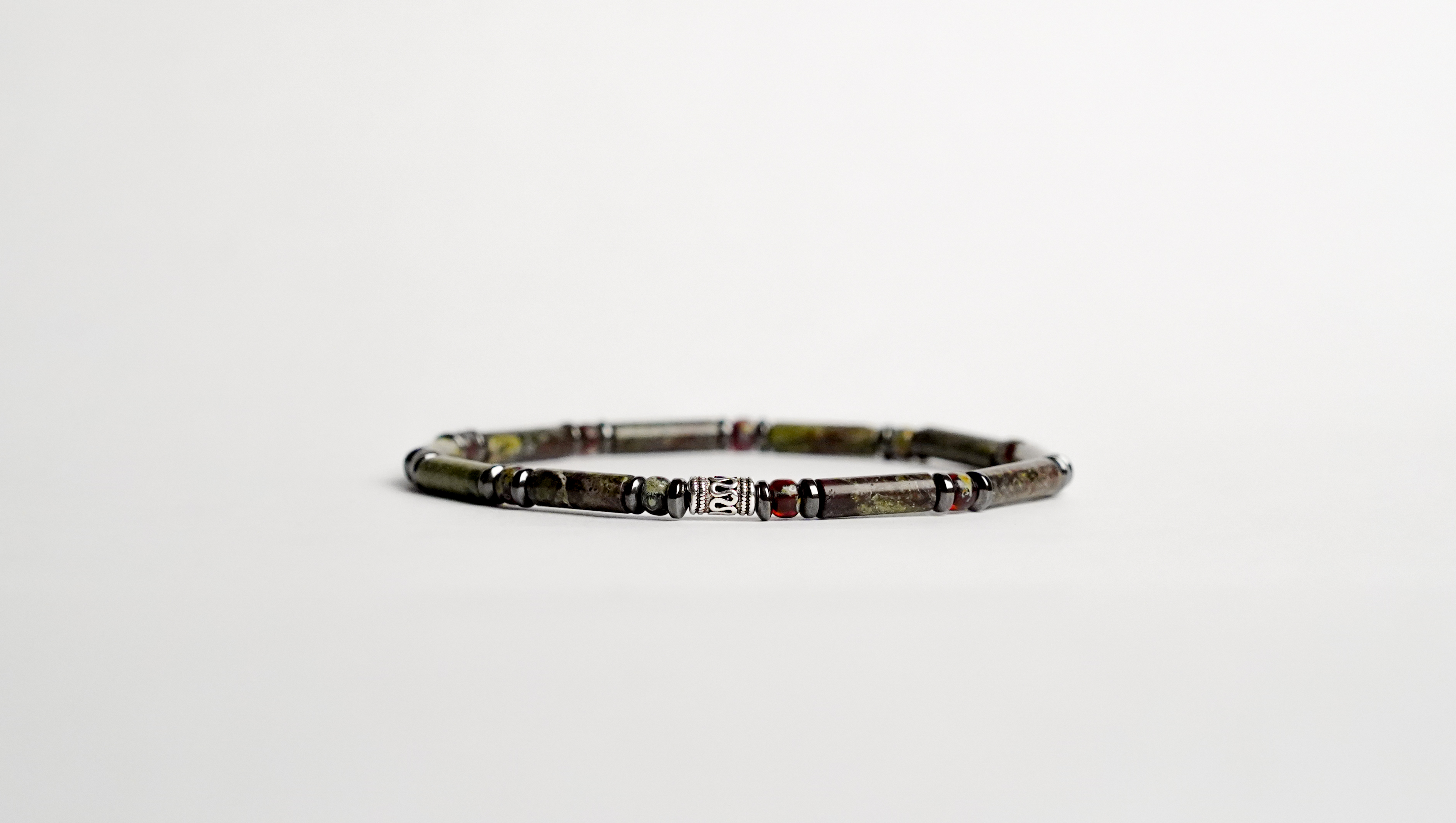 Il bracciale è realizzato con tubi di Diaspro Sangue di drago, vetro Miyuki ed ematite. Rifinito con accenti in Argento sterling 925.